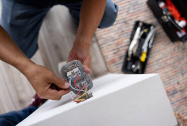 Close-up on a repairman fixing an electrical outlet - electricity concepts