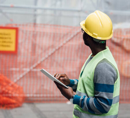 Portrait of a young African American engineer working at the construction site.